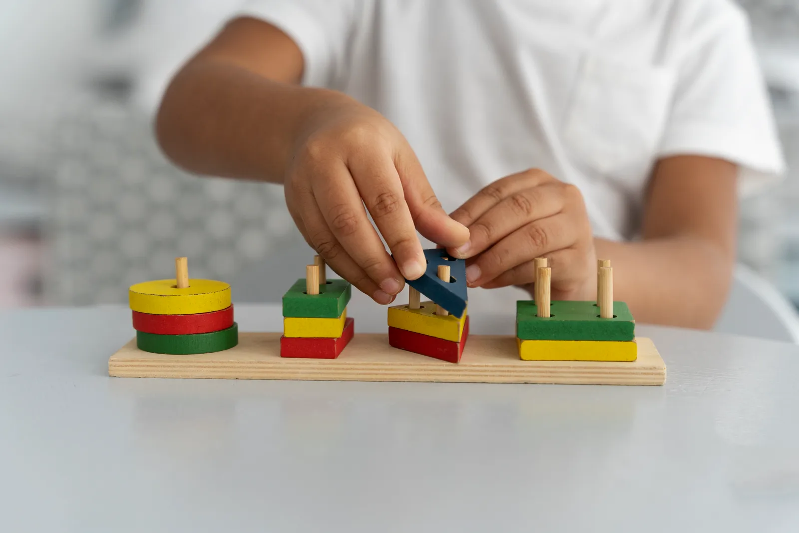 A child learning with a colourful Montessori wooden activity